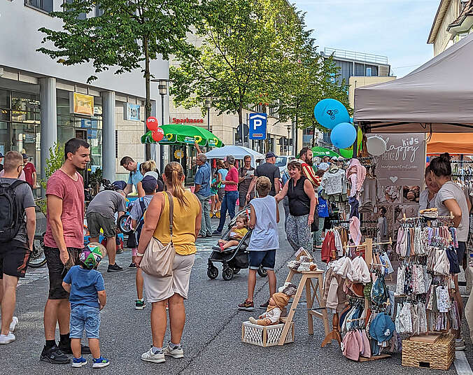 Menschen auf der Straße mit Verkaufsständen