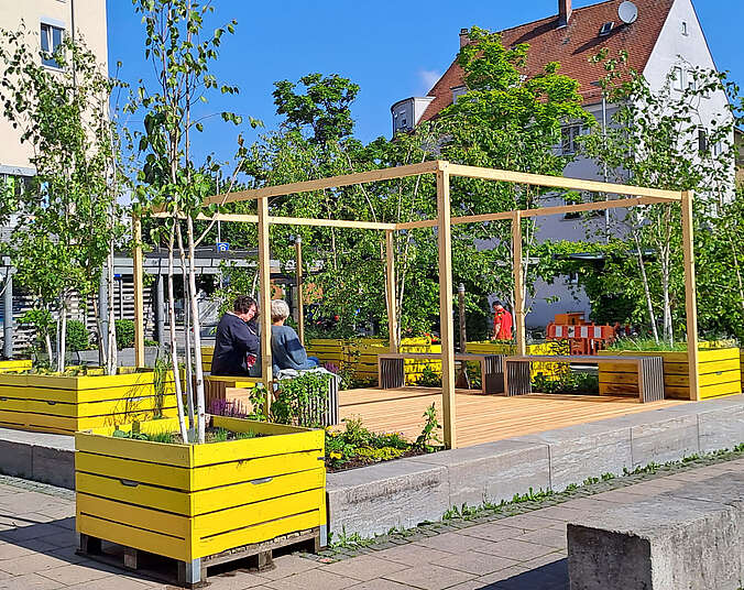 Gelbe Pflanzkisten, Bäume, Planzen, Beeren und Bänke auf dem Franziskusplatz