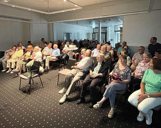 Personen sitzen in Reihen in einem Raum