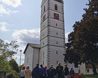 Kirchturm mit Personengruppe