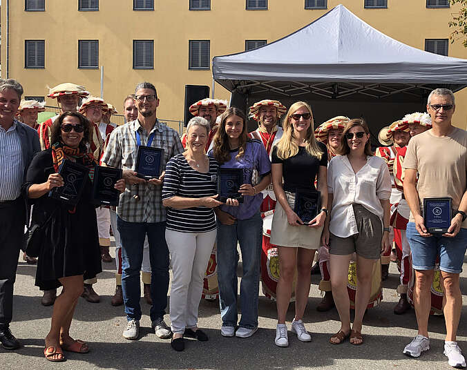 Münner und Frauen mit Glastrophäen, dahinter der Seehasenfanfarenzug