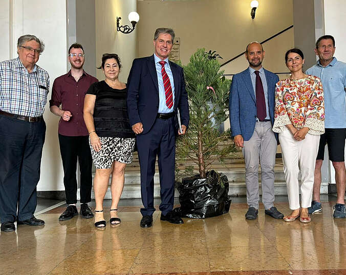 Gruppenbild mit sieben Menschen und einem Mammutbaum.